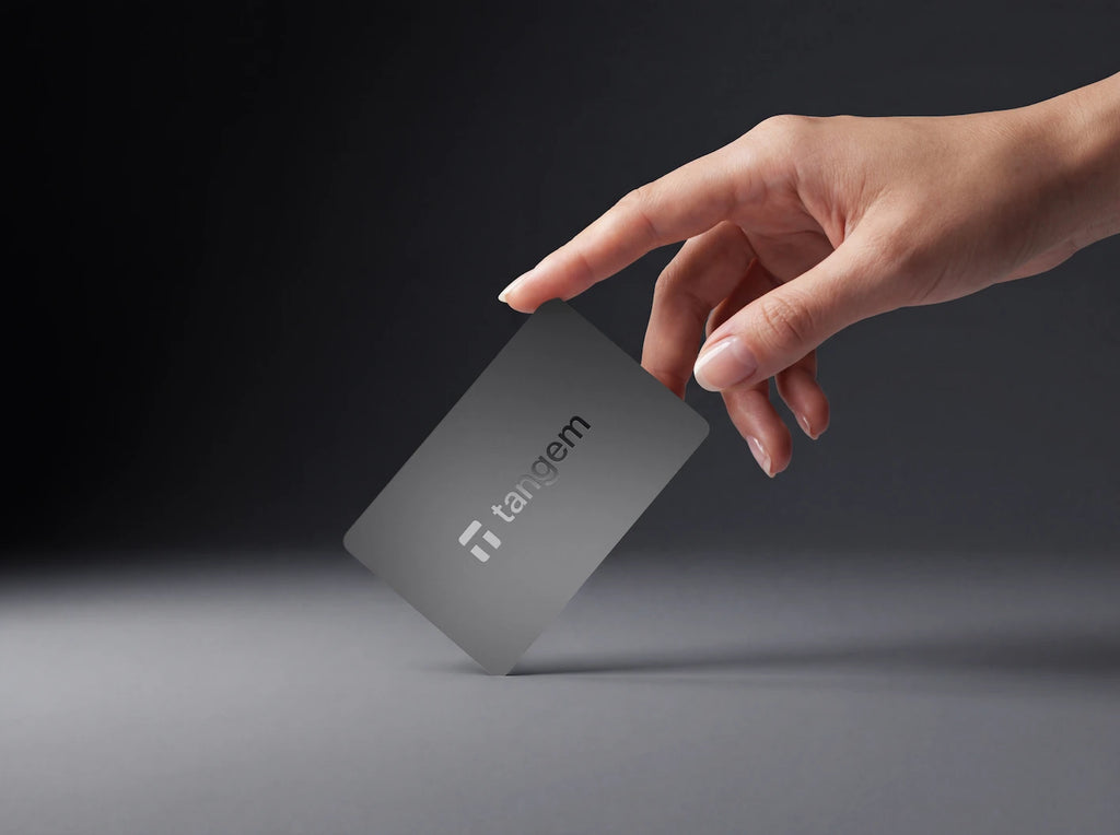 Tangem Black crypto wallet card held in hand